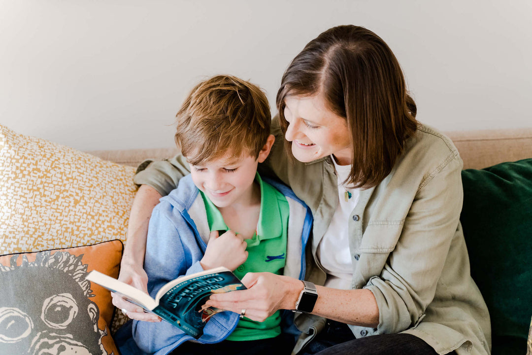 A mother and son sitting together and reading a book from a Parrot Street Book Club subscription box