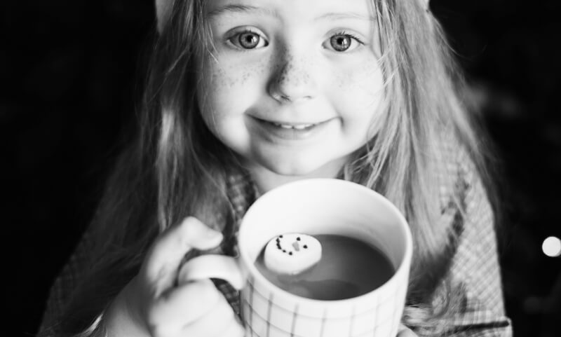 Girl enjoying a snowman hot chocolate on Christmas Eve