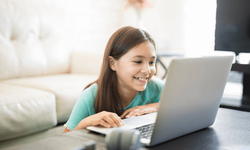 Girl smiling while looking at a laptop screen