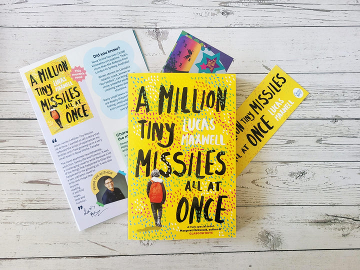 Book titled 'A Million Tiny Missiles All at Once' with a bookmark on a wooden surface