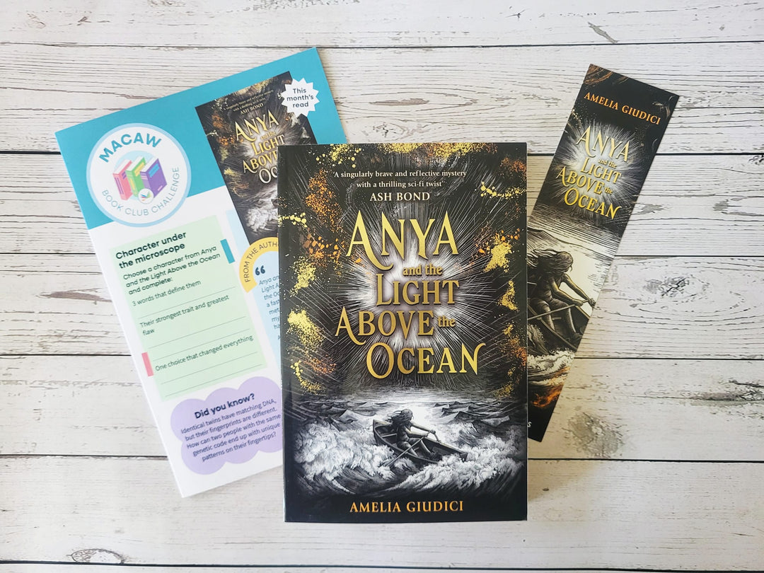 Book titled 'Anya and the Light Above the Ocean' by Amelia Giulici with promotional material on a wooden surface.