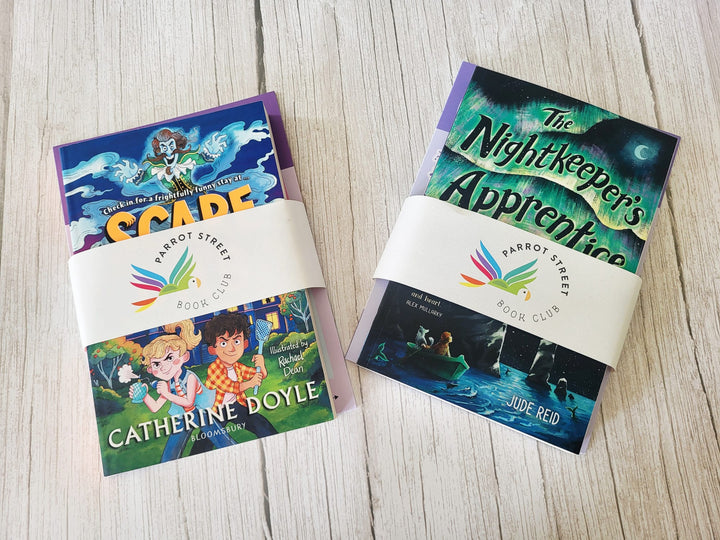 Two children's books with 'Carrot Street Book Club' labels on a wooden surface