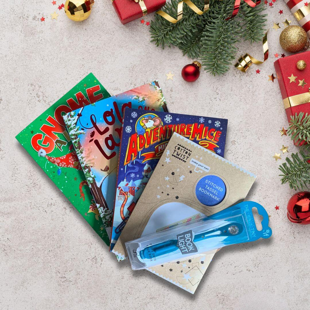 Collection of children's books and a booklight on a festive background with Christmas decorations.