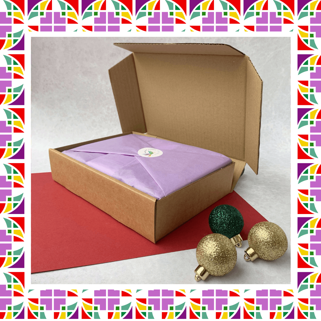 Tissue-wrapped book gift set in a box with christmas decorations and a colourful border