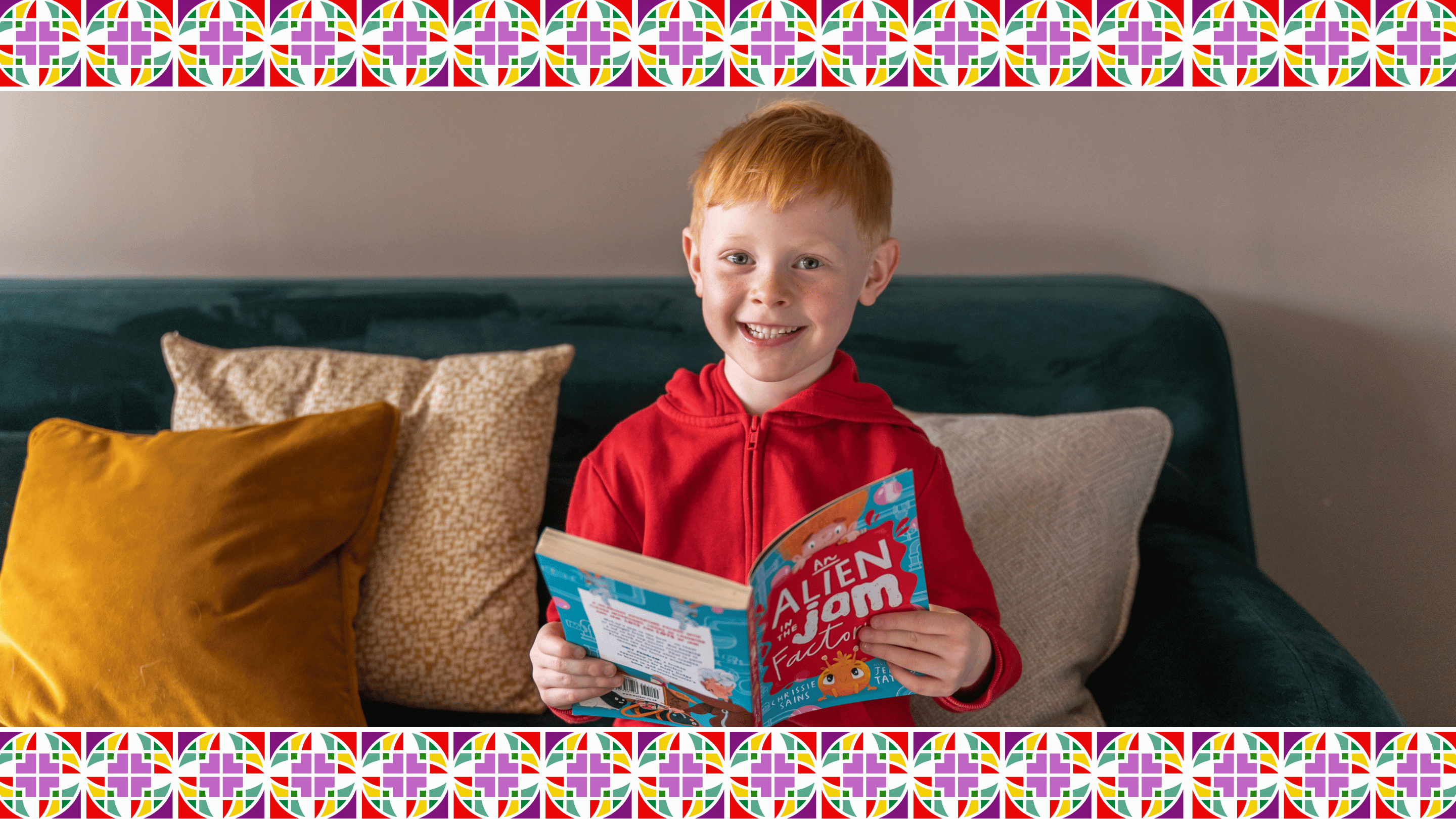 Child in red hoodie holding a book on a green couch with colorful border