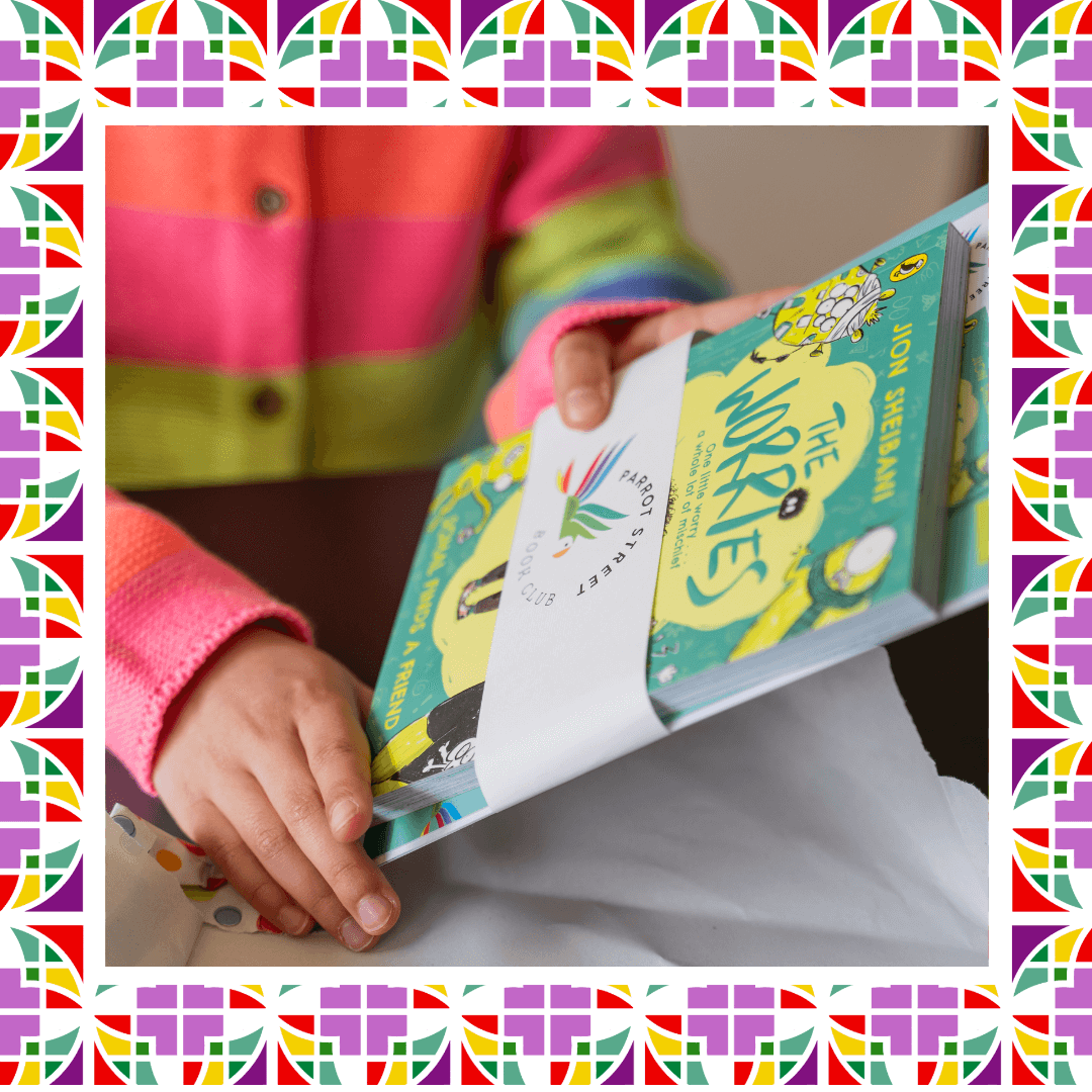 Child unwrapping a book titled 'The Worries' wrapped in a Parrot Street Book Club band and with colourful border