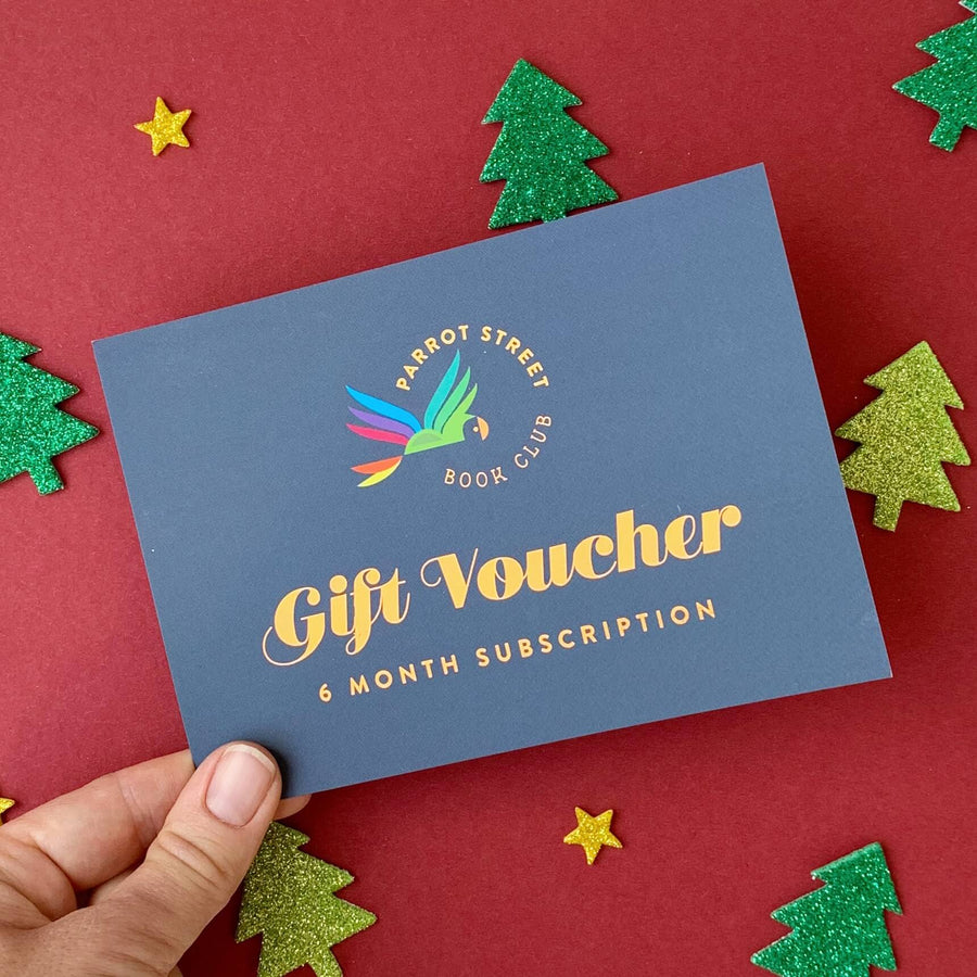 Gift voucher for a 6-month subscription held over a red background with decorative trees and stars.