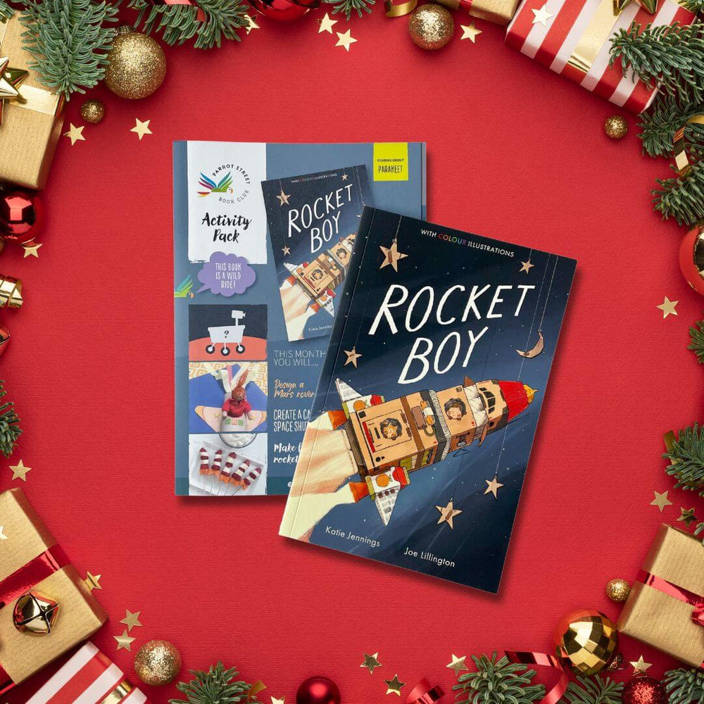 'Rocket Boy' with activity pack on a red background with Christmas decorations.
