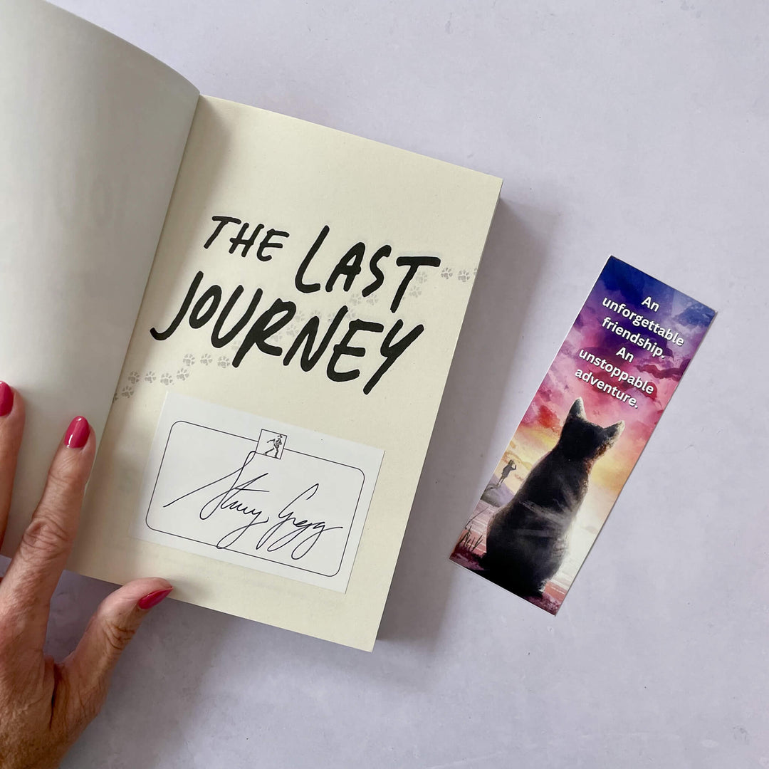 Book titled 'The Last Journey' with a signed bookplate and bookmark featuring a cat on a gray background