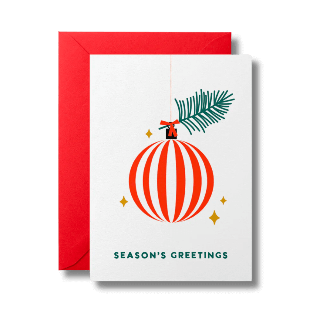 Christmas card reading Season's Greetings below a red and white striped bauble surrounded by gold stars. Card is accompanied by a festive red envelope.